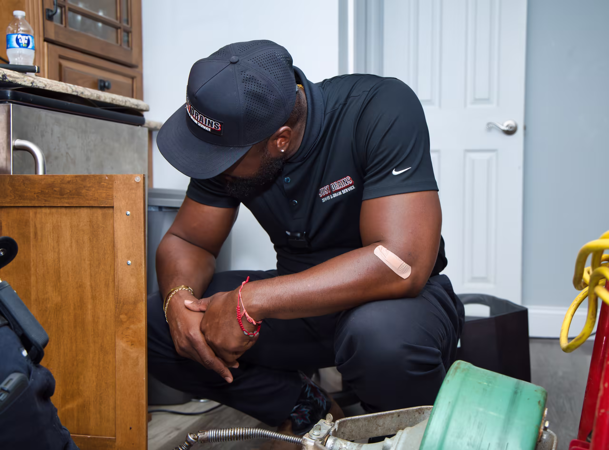 Drain cleaning technician working under kitchen sink