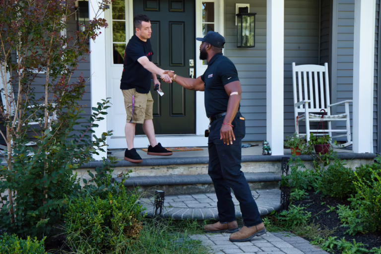Drain service technician greeting homeowner on front porch