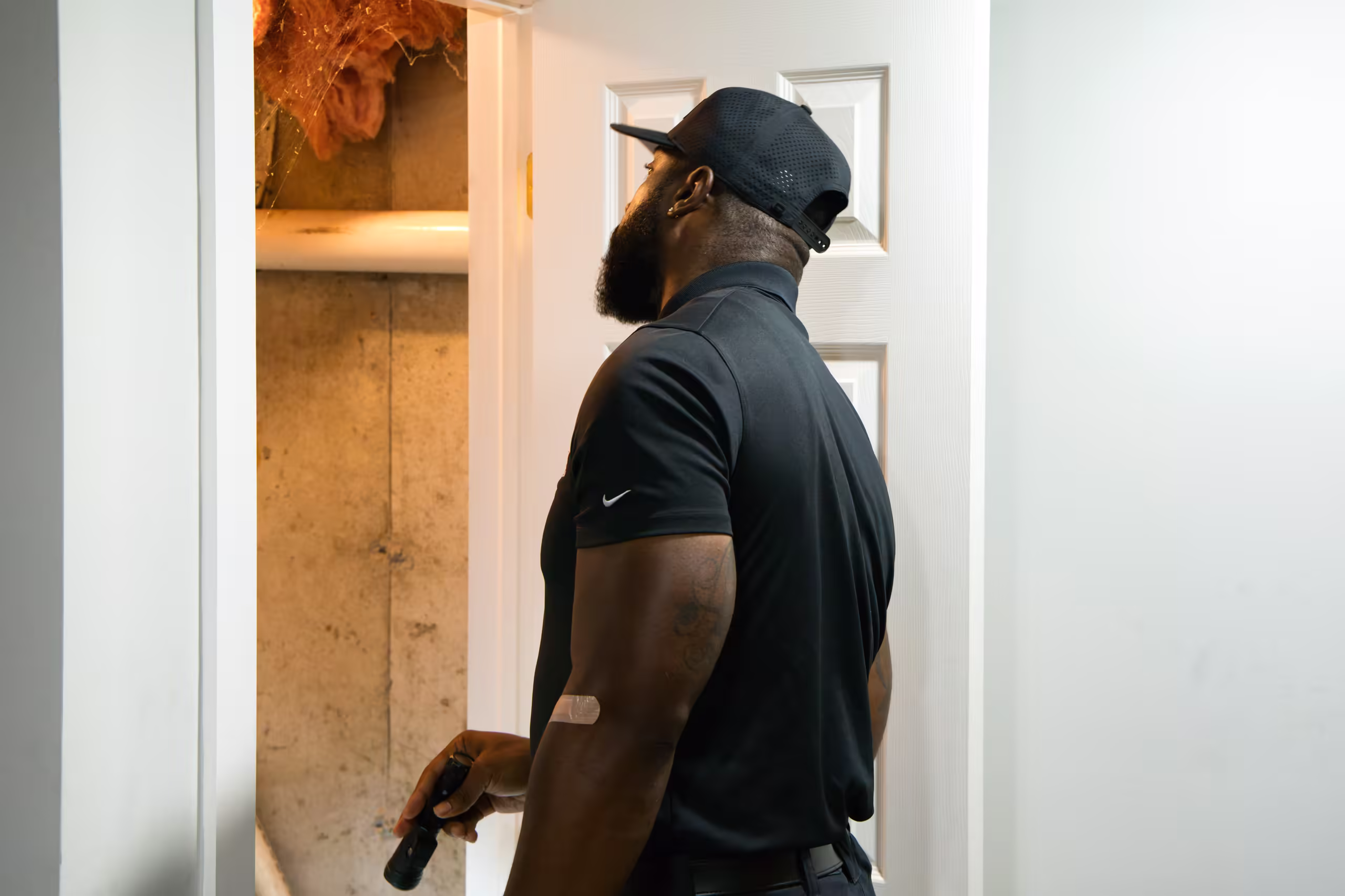 Drain technician inspecting basement utility closet